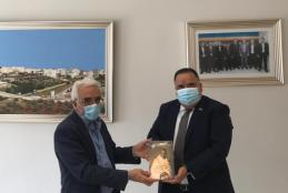 The Ambassador of the Embassy of India gifting a book about the life of Gandhi to AAUP 
